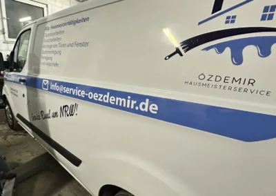 Kraftfahrzeug mit Handwerksdienste, Hausmeisterservice und Logo in weiß und blau.